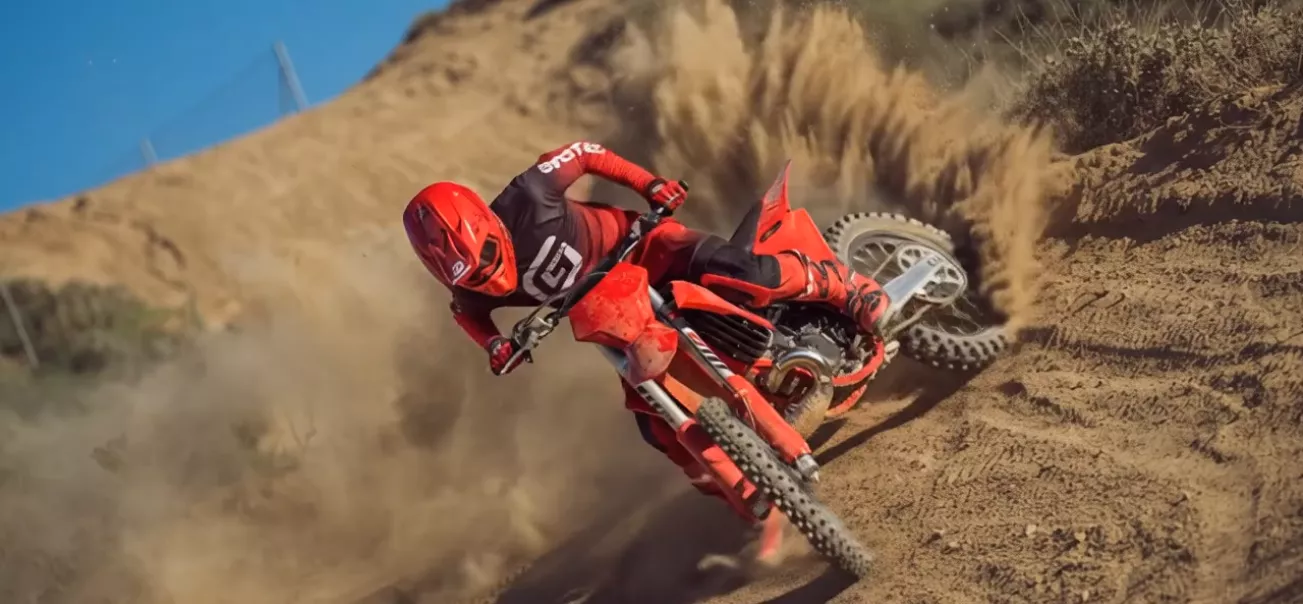 Motorcrosser in een bocht op een zandpiste