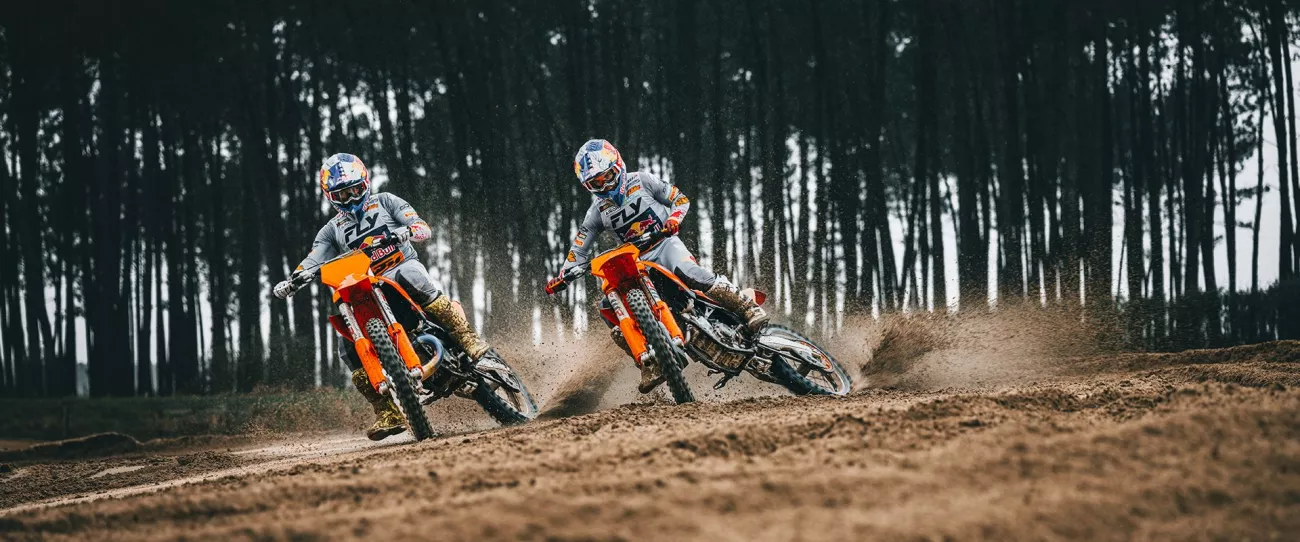 Twee motorcrossers in een bocht in het bos