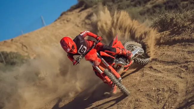 Motorcrosser in een bocht op een zandpiste