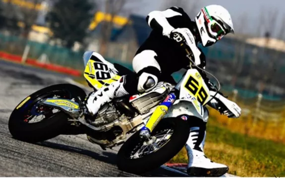 Supermotorijder in een bocht op asfalt